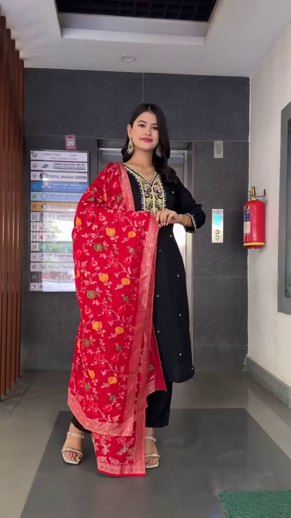 Black Straight-Cut Kurta Set with Intricate Multicolor Thread Embroidery and Mirror Work on Neckline, Paired with Matching Bottoms and a Rich Red Velvet Floral Printed Dupatta – Perfect for Festive Celebrations and Evening Occasions