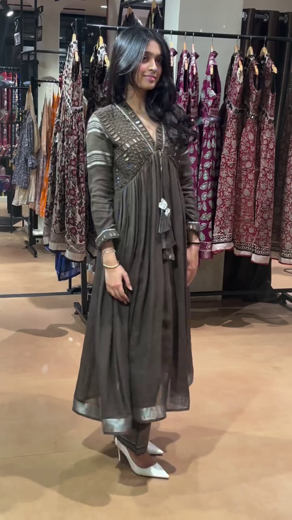 Stunning Black Flared Anarkali Suit Featuring Intricate Mirror and Thread Embellishments on Yoke and Sleeves, Paired with Matching Pants and Elegant Tassel Detailing – Perfect for Festive and Evening Wear