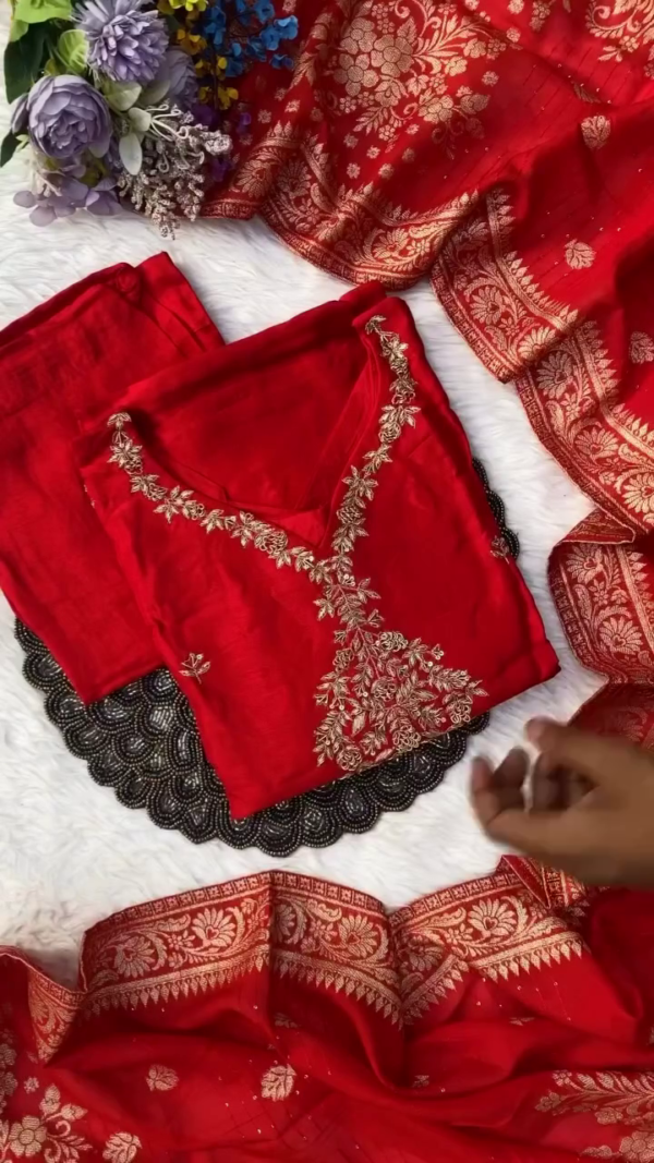 Rich red suit adorned with golden thread embroidery on the front and sleeves. Completed with a matching dupatta featuring an ornate floral border.
