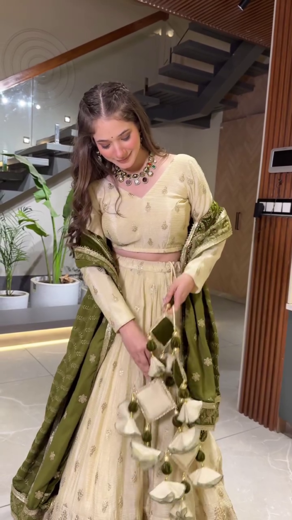 Elegant Cream and Olive Green Ethnic Lehenga Set Featuring Subtle Golden Embroidery, Full-Sleeve Blouse, Rich Woven Dupatta, and Coordinated Latkan Tassels – A Refined Traditional Ensemble Perfect for Engagements, Sangeet Functions, and Festive Celebrations - Image 2