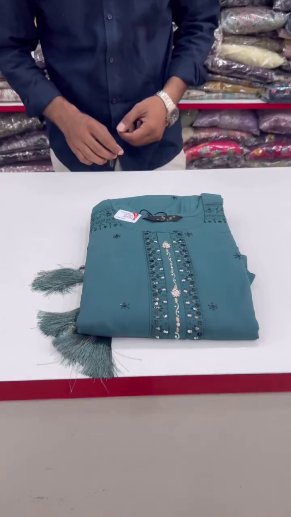Teal Elegance – A Refined Three-Piece Suit in Deep Teal with Subtle Mirror Work on the Neckline, Delicate Embroidery on the Hem, and a Graceful Golden-Printed Dupatta for a Balanced Traditional Appeal.