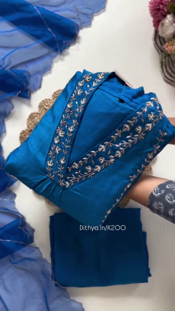 Royal Blue Silk-Blend Suit Set Featuring Intricate Silver Floral Embroidery on the Neckline and Panels – Paired with a Delicate Ruffled Organza Dupatta for an Elegant and Festive Ethnic Look